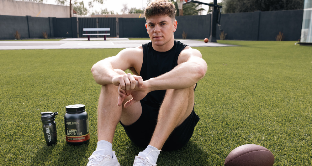cooper dejean on football field with optimum nutrition products