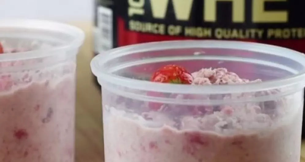 Flocons d’avoine à la fraise avec protéine Whey, servis dans des pots en plastique.