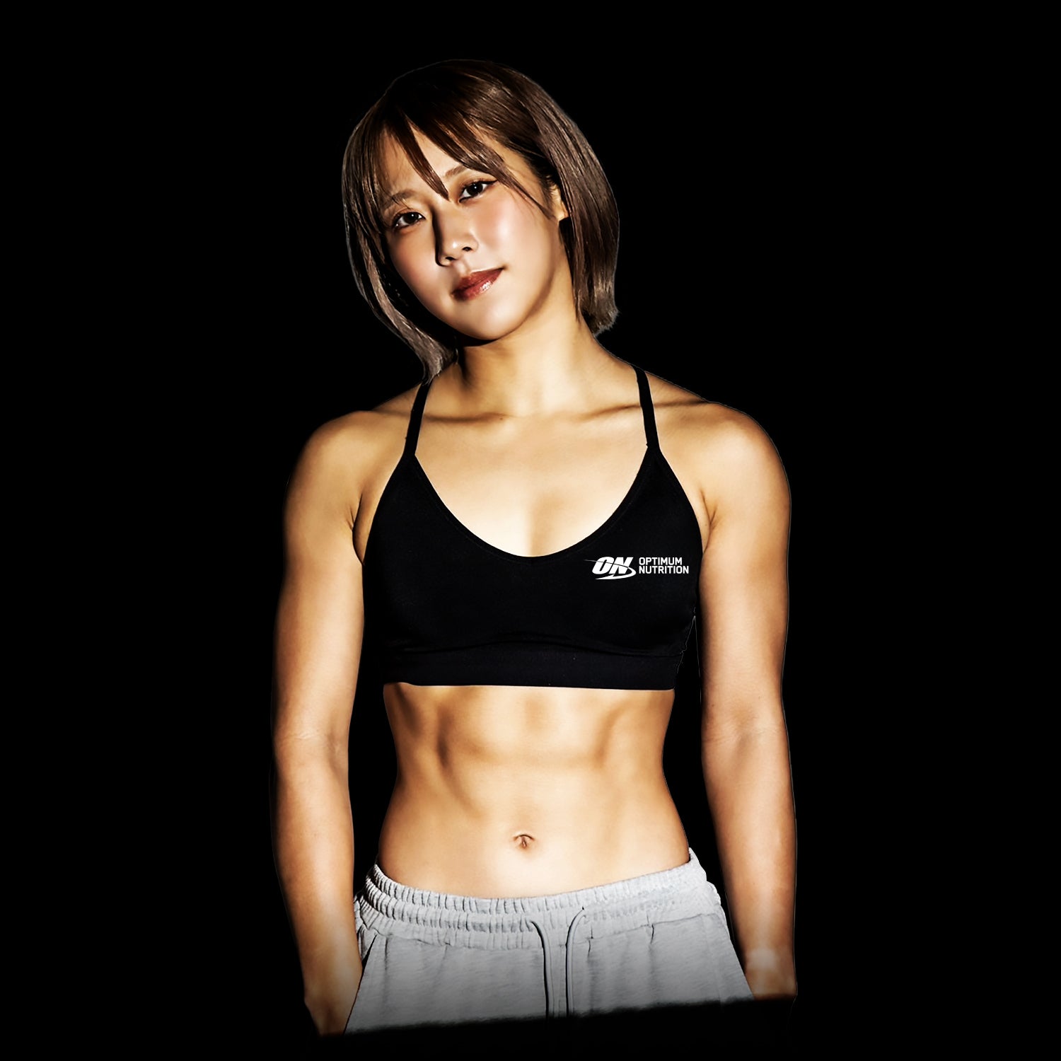 Fitness model wearing a black Optimum Nutrition sports bra, showcasing a toned physique