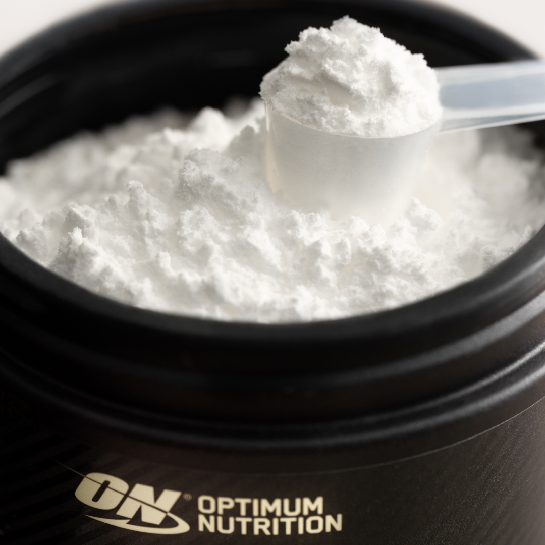 Optimum Nutrition Gold Standard 100% Whey Protein powder in a container with a scoop