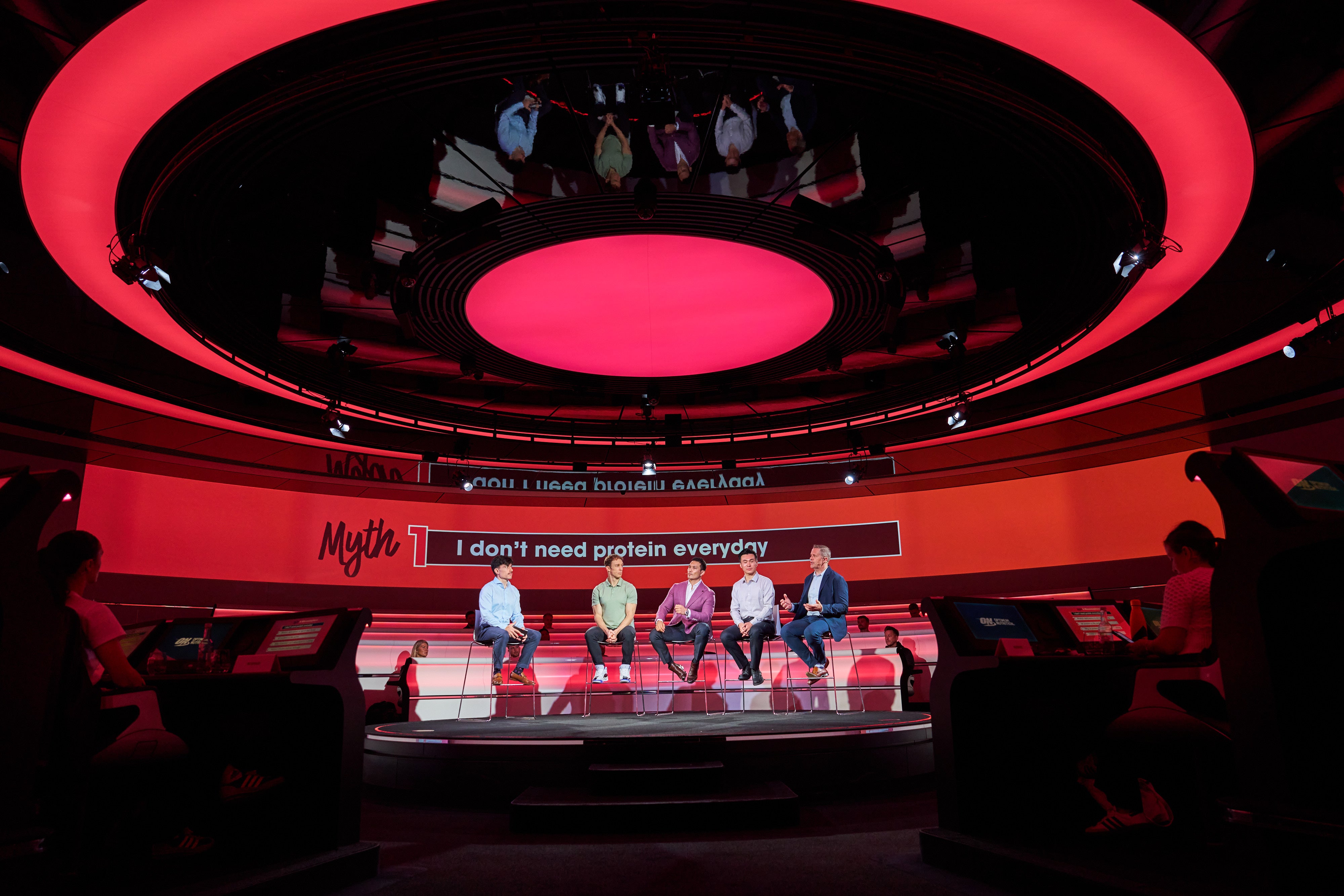 A panel of five people seated on a stage discussing protein-related topics