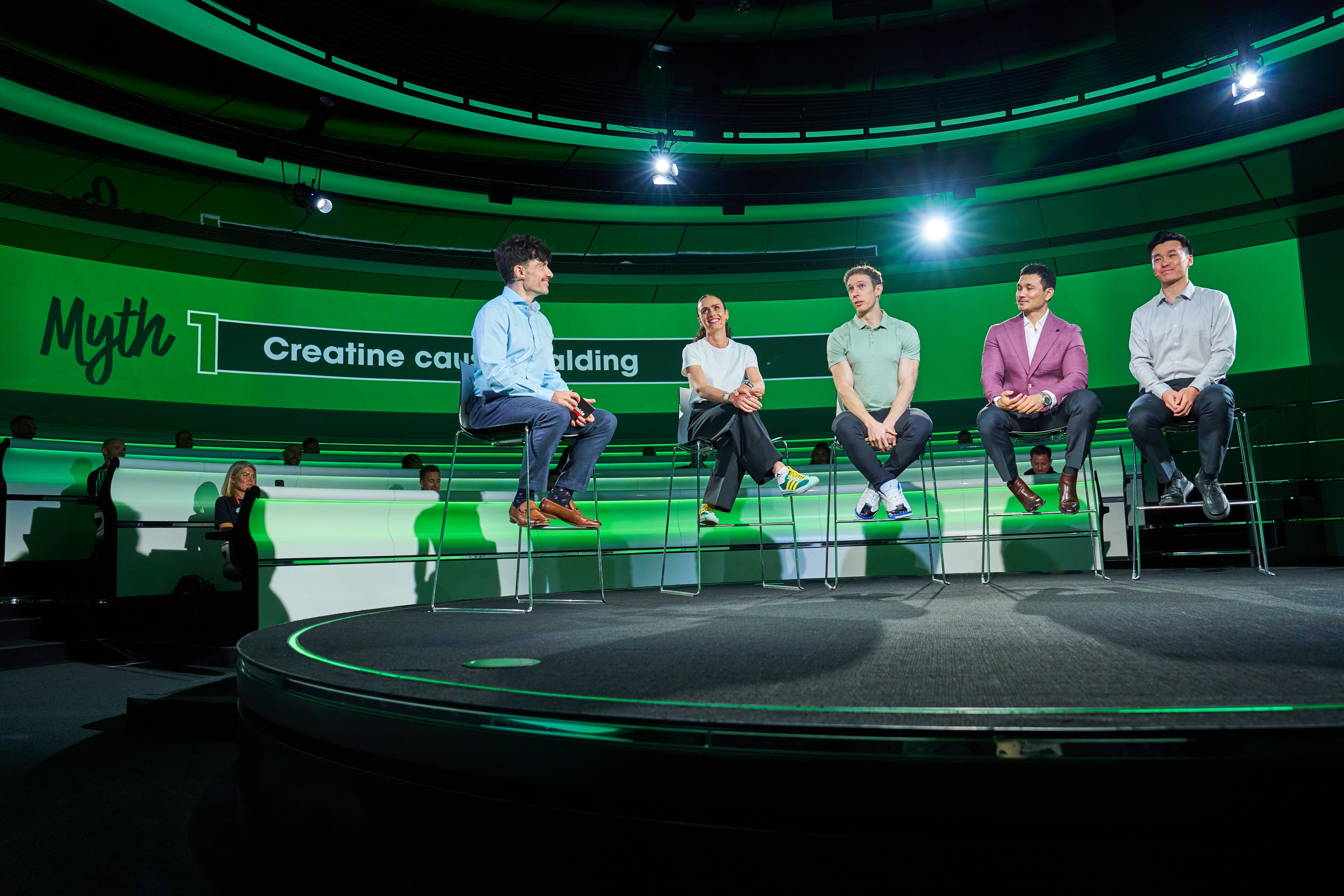 A group of five people seated on a stage discussing topics related to creatine and muscle building
