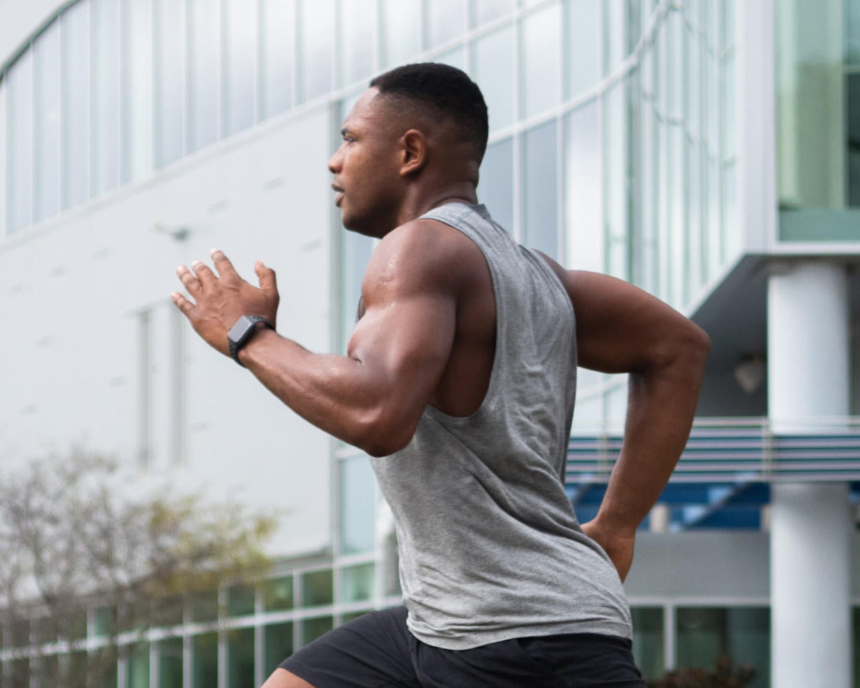 A man running outdoors in athletic wear, showcasing fitness and high-intensity workout