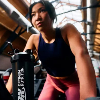 Optimum Nutrition shaker bottle in a gym setting, used for mixing supplements like whey protein or amino energy drinks