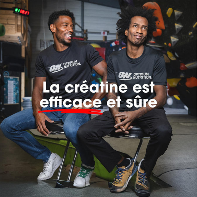 Two people wearing Optimum Nutrition branded shirts sitting on stools in a gym setting