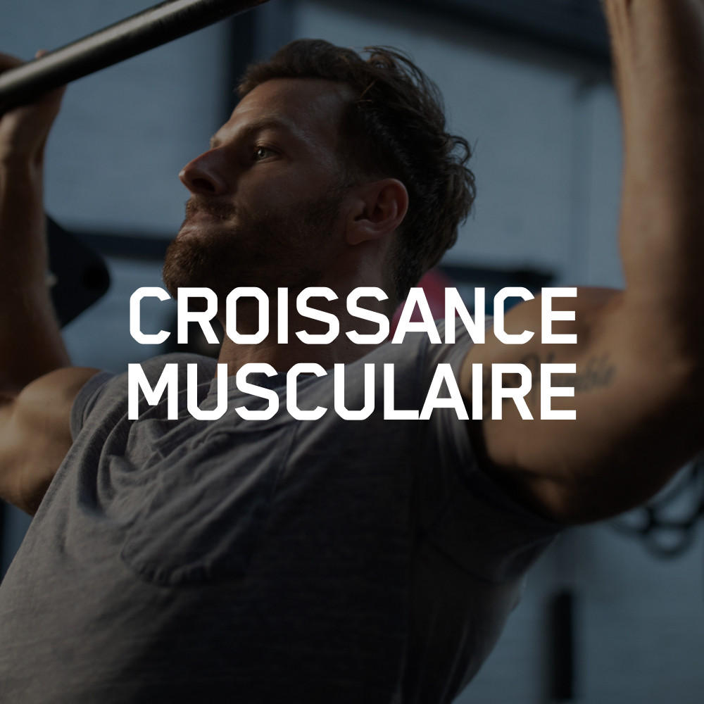 Man performing pull-up exercise in gym, emphasizing muscle growth