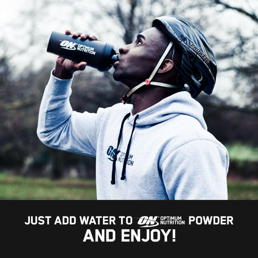Optimum Nutrition shaker bottle being used by a person outdoors, wearing a helmet and hoodie