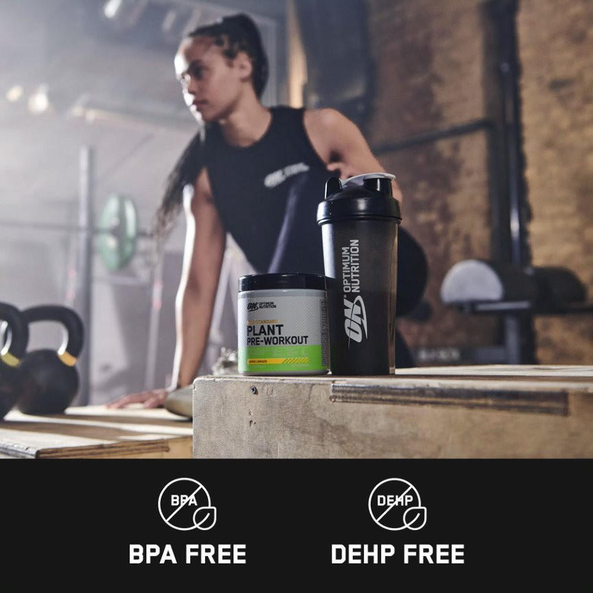 Optimum Nutrition plant pre-workout supplement and shaker bottle on a gym bench, labeled BPA and DEHP free