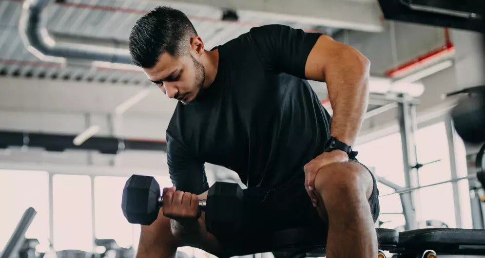 man doing curls in the gym