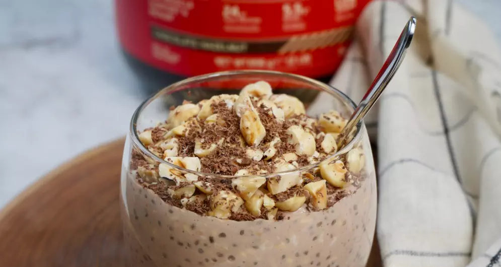 Glass with Chocolate Hazelnut Overnight Oats standing in front of a Gold Standard Whey Tub