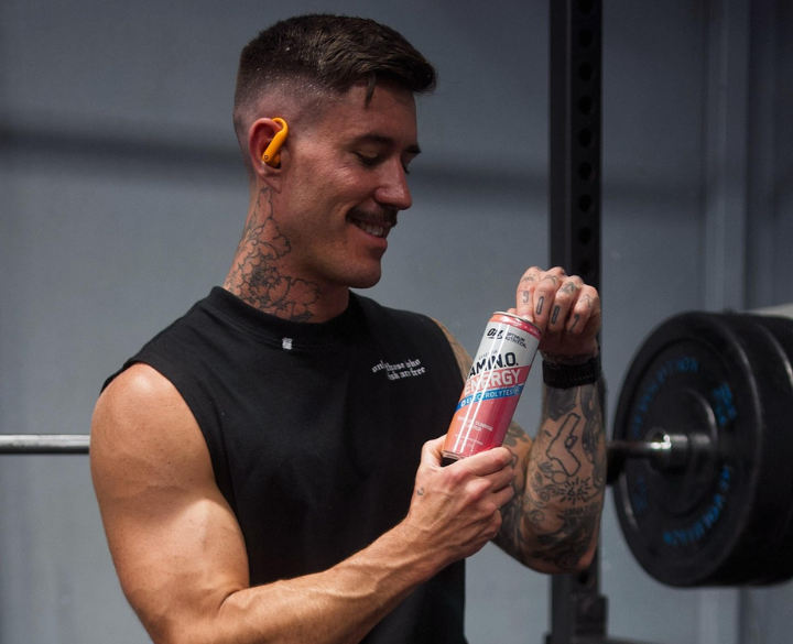 Man holding a can of amino acid energy formula, suitable for post-workout nutrition and high-intensity workouts