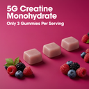 Three pinkish-beige gummy candies arranged on a bright pink background with white text reading '5G Creatine Monohydrate' and 'Only 3 Gummies Per Serving,' plus berry and mint garnish.