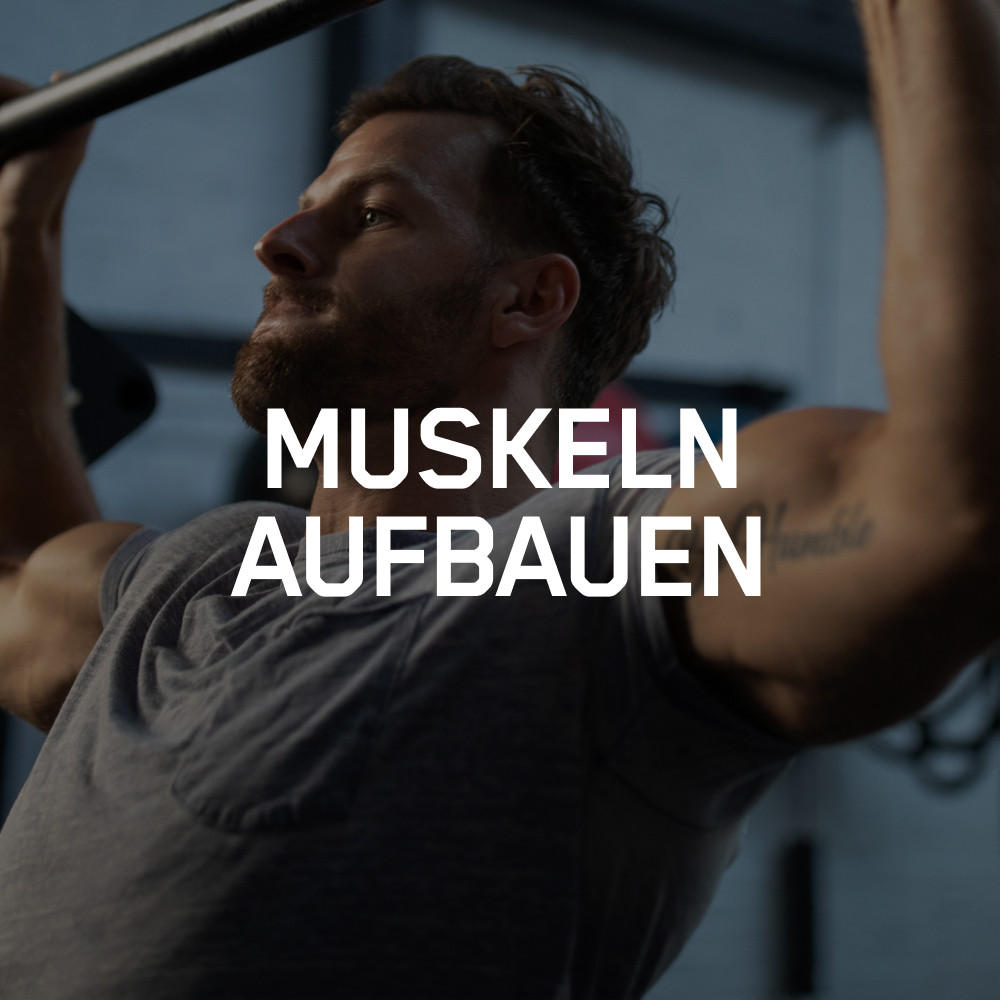 Man performing pull-ups in a gym setting, focusing on muscle building