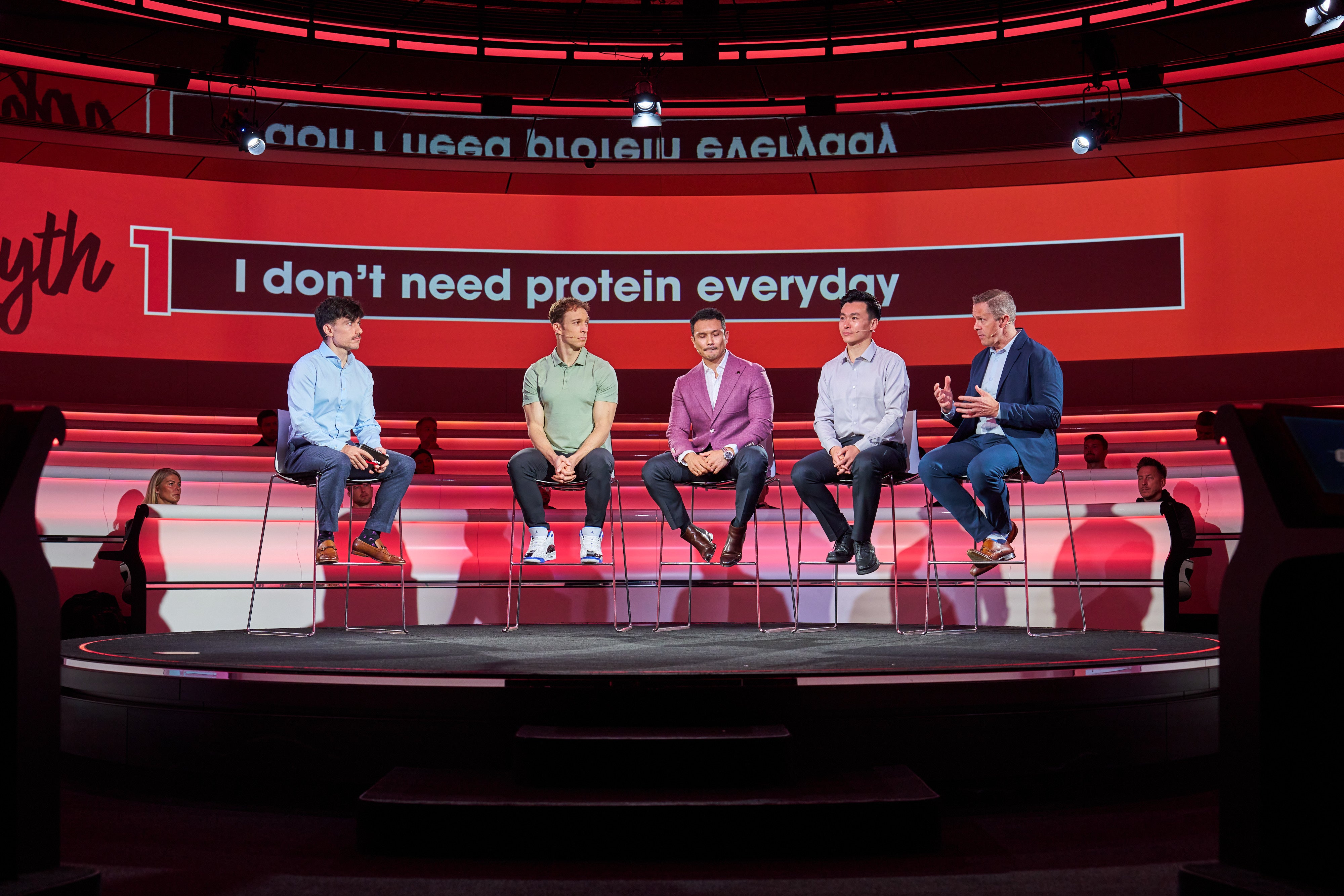 Panel discussion on protein consumption myths, featuring five individuals seated on stage