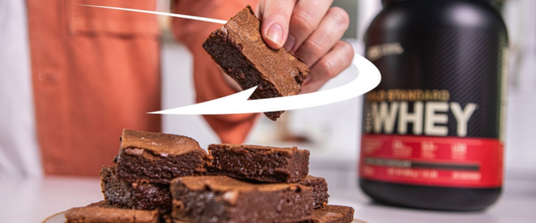 Optimum Nutrition Gold Standard 100% Whey Protein container next to a stack of brownies