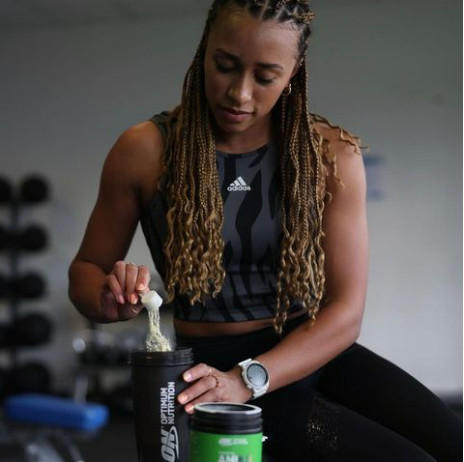 Person preparing Optimum Nutrition protein shake with ON Micronised Creatine, ideal for post-workout nutrition and muscle building