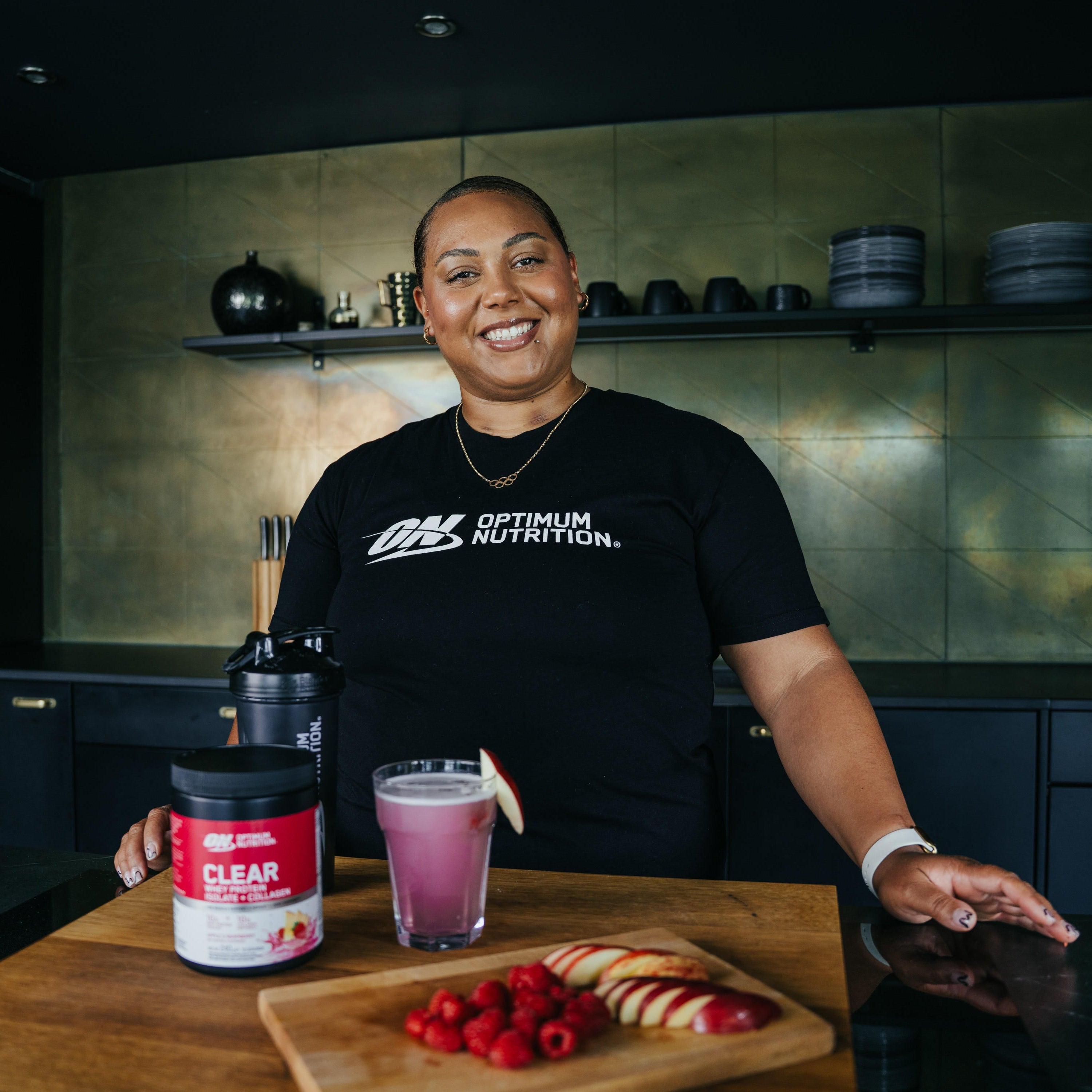 Optimum Nutrition BCAA Powder Raspberry Pomegranate flavour next to a glass with a fitness enthusiast