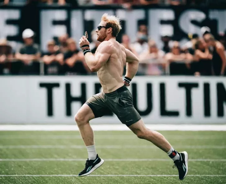 A man running on a track, possibly during a fitness event or competition