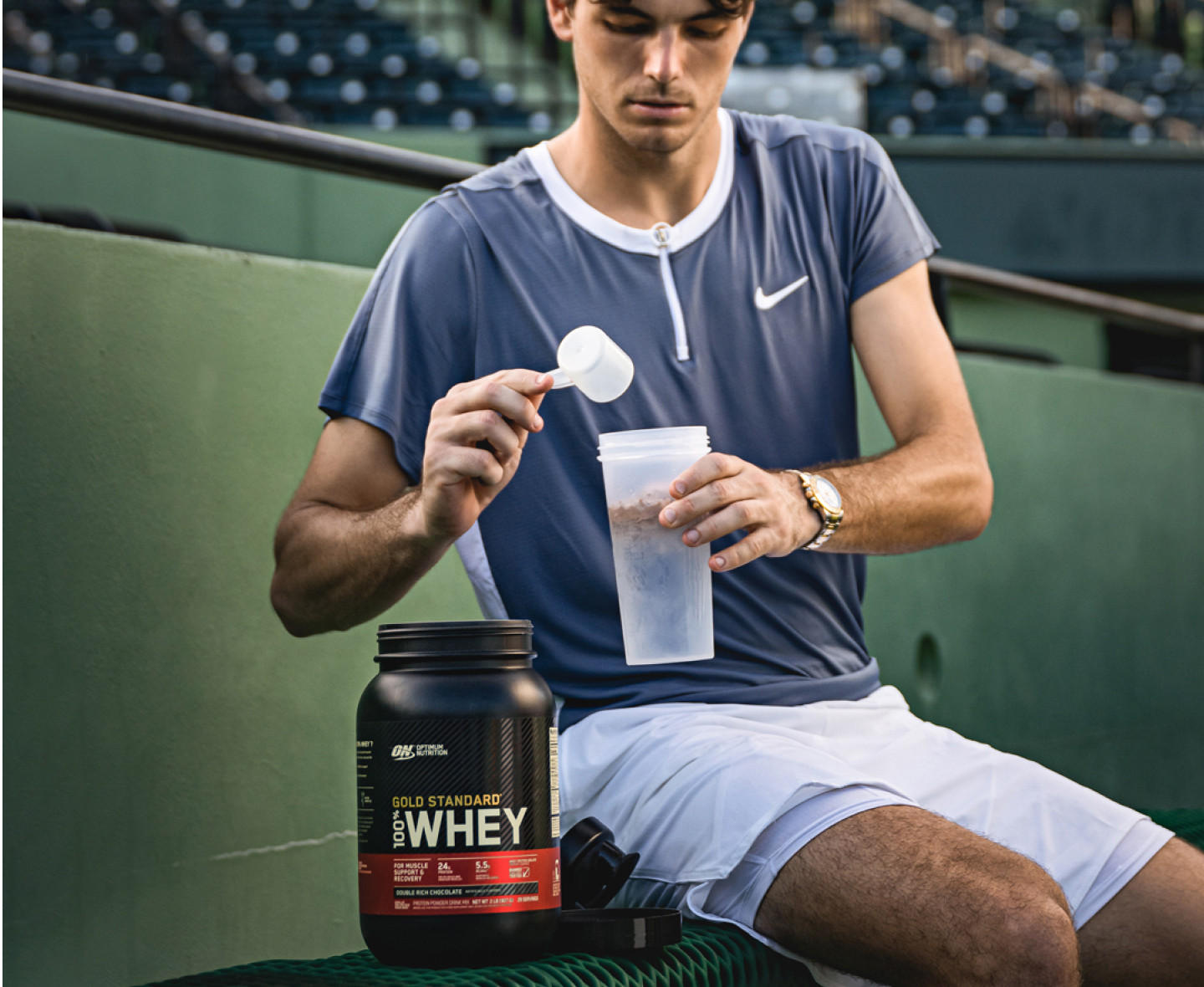 Optimum Nutrition Gold Standard 100% Whey Protein, 2.73 kg container, being prepared in a shaker by a person