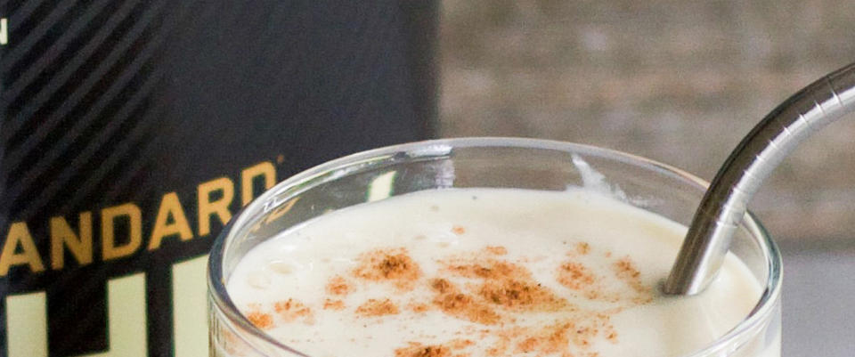 Optimum Nutrition Gold Standard 100% Whey Protein shake in a glass with a metal straw