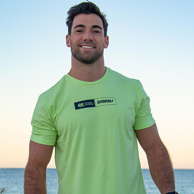 Man wearing a green Optimum Nutrition branded T-shirt outdoors