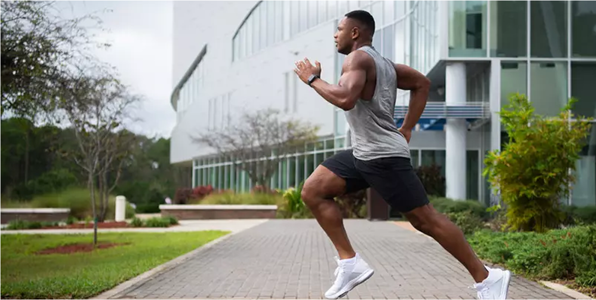 A person running outdoors near a modern building, possibly engaging in fitness or workout activities