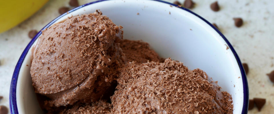 Chocolate ice cream in a white bowl with chocolate shavings on top