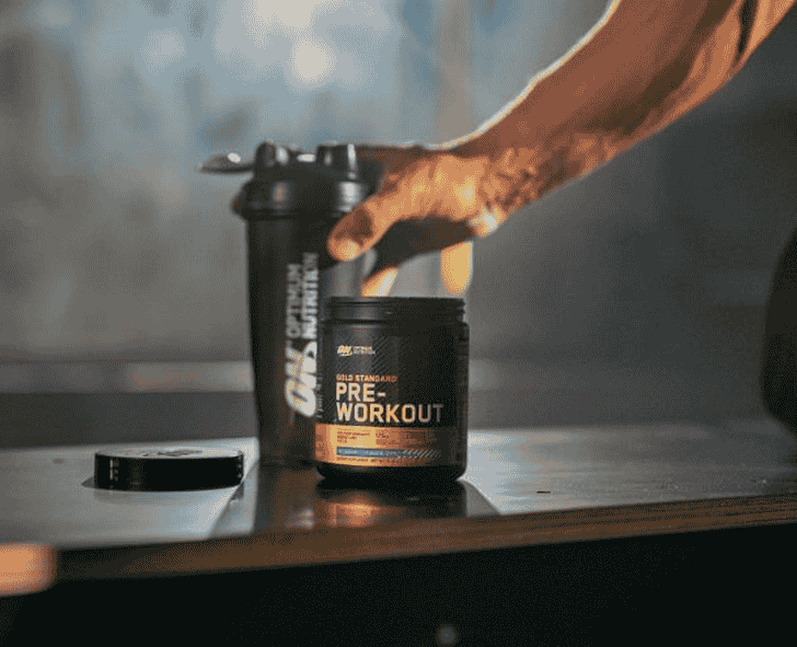 Optimum Nutrition Gold Standard Pre-Workout supplement container next to a shaker bottle