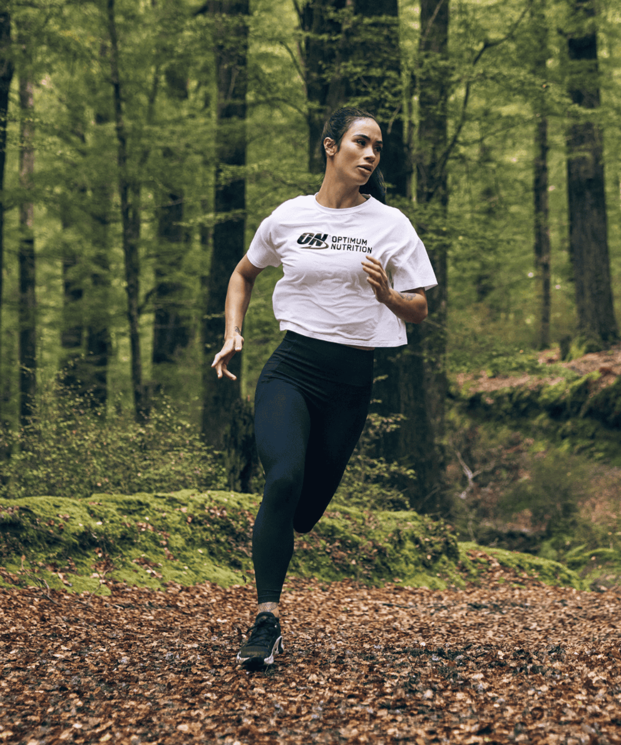 Person running in a forest wearing an Optimum Nutrition t-shirt