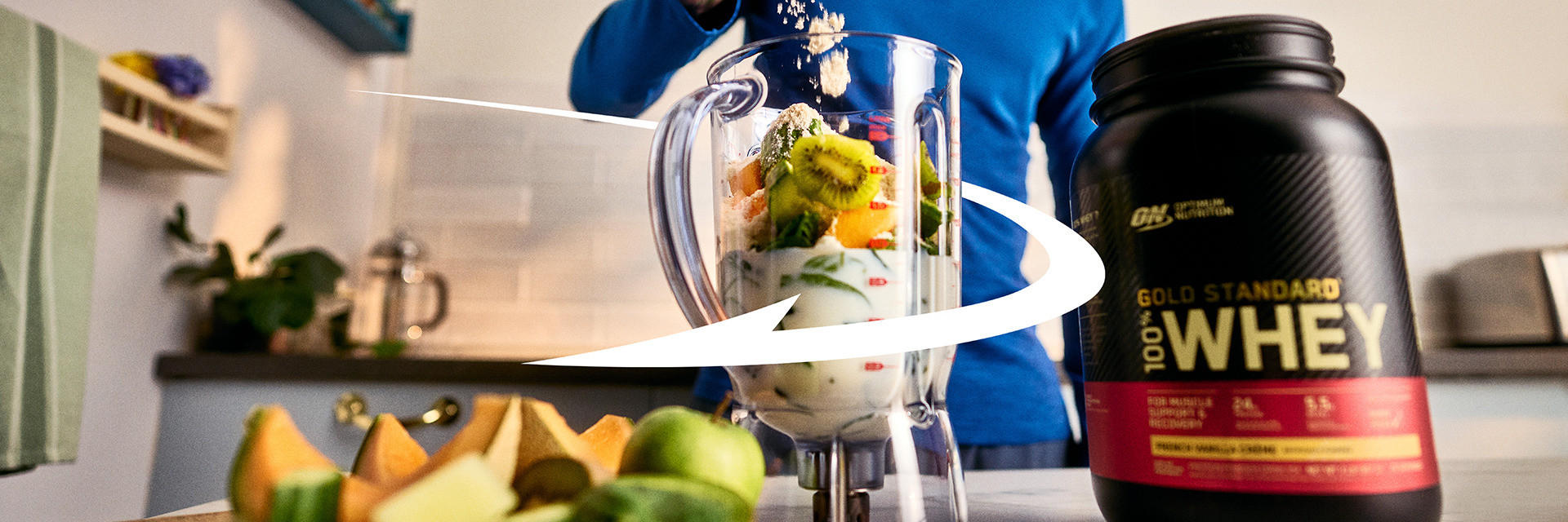 Optimum Nutrition Gold Standard 100% Whey Protein container next to a blender with fruits, ideal for post-workout nutrition