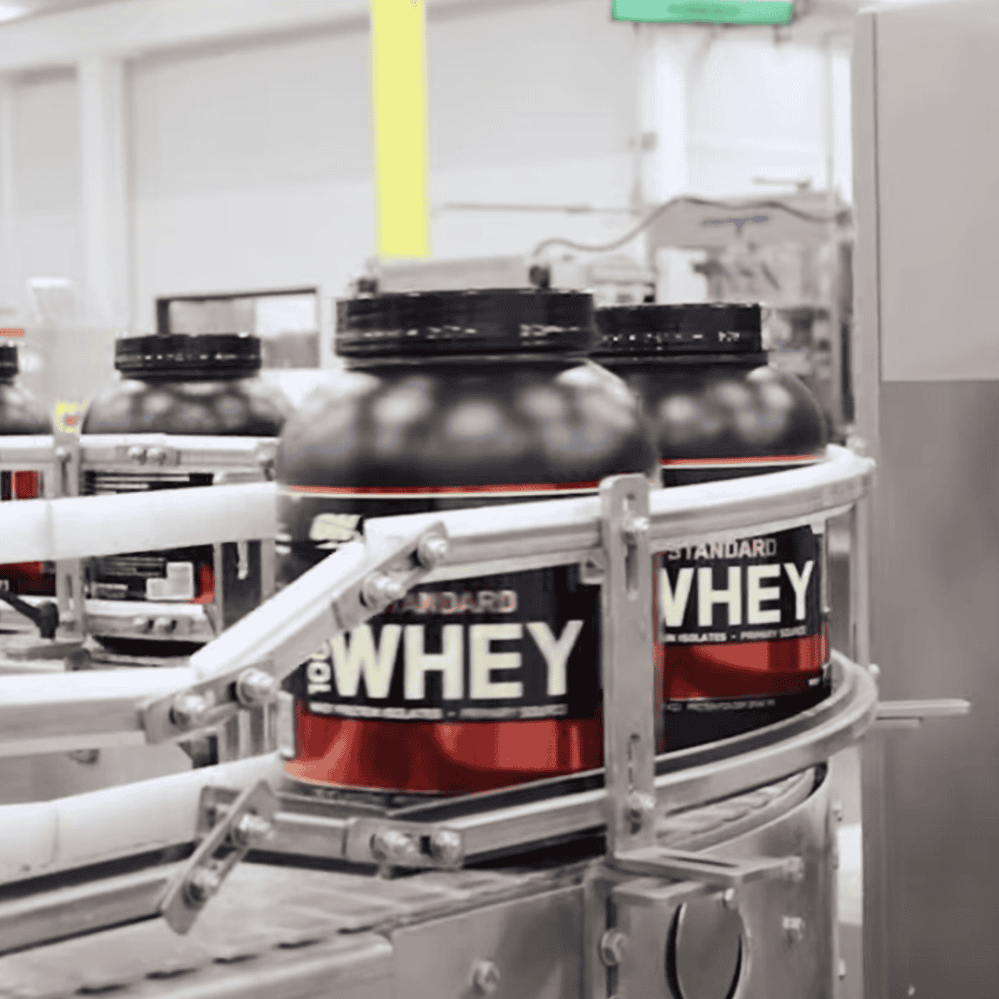 Optimum Nutrition Gold Standard 100% Whey Protein containers on a production line