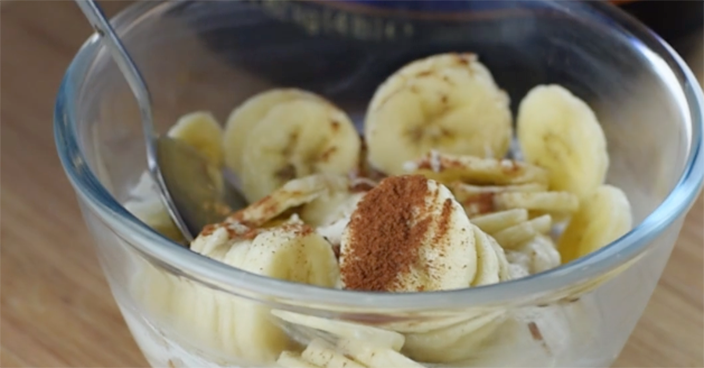 Bowl of sliced bananas with a sprinkle of cinnamon, served with yogurt or cereal