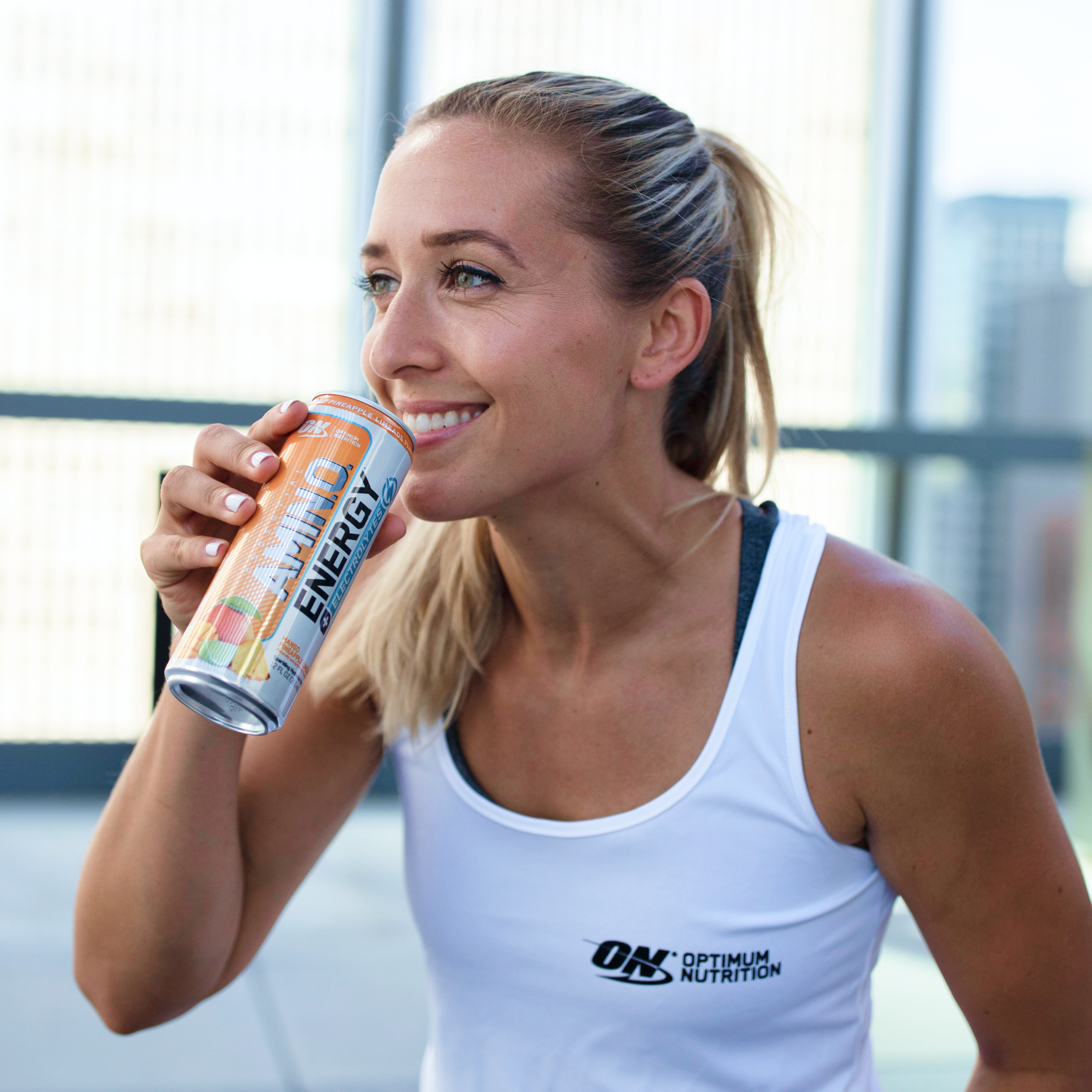 woman drinking can of amino energy electrolytes