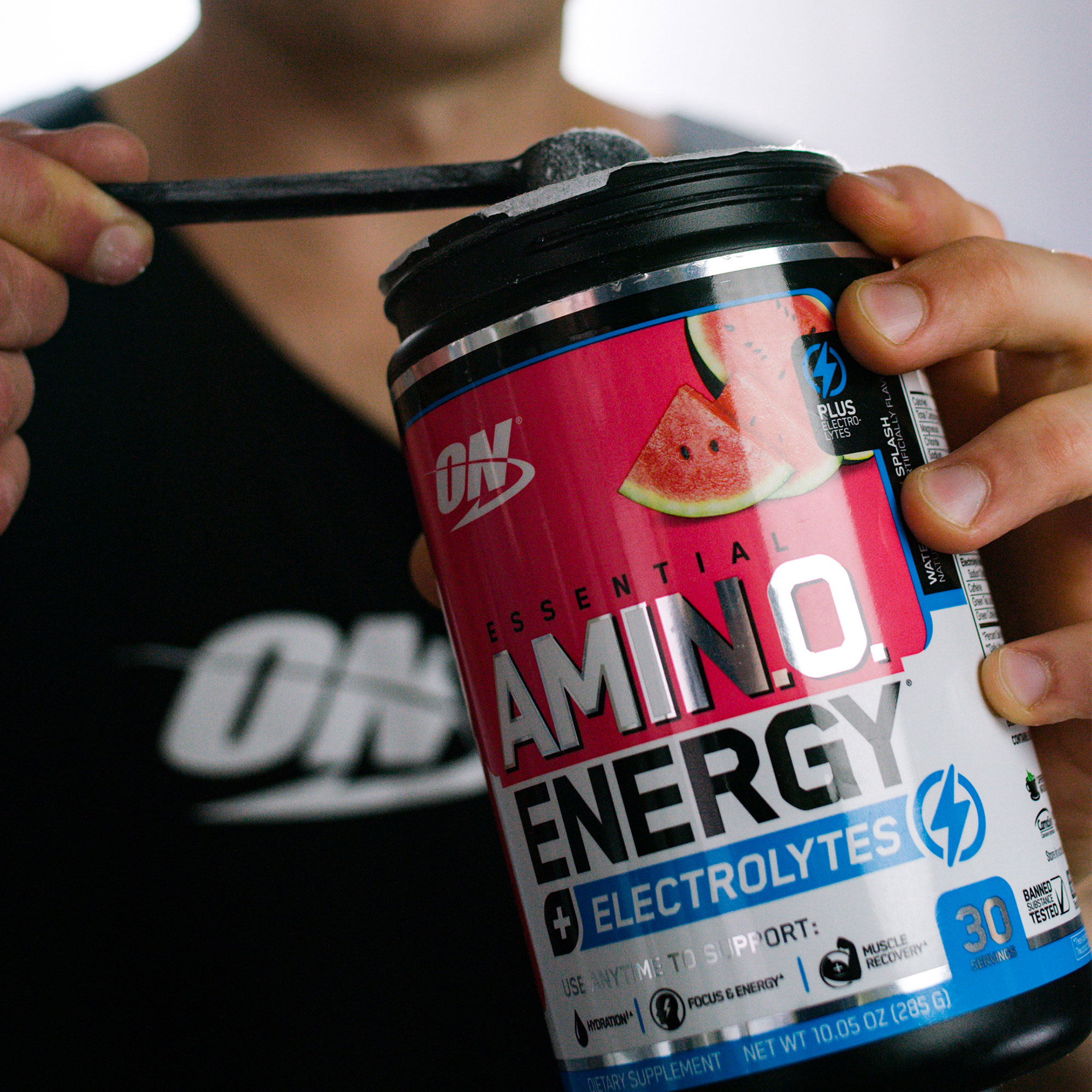 man taking a scoop of amino energy + electrolytes