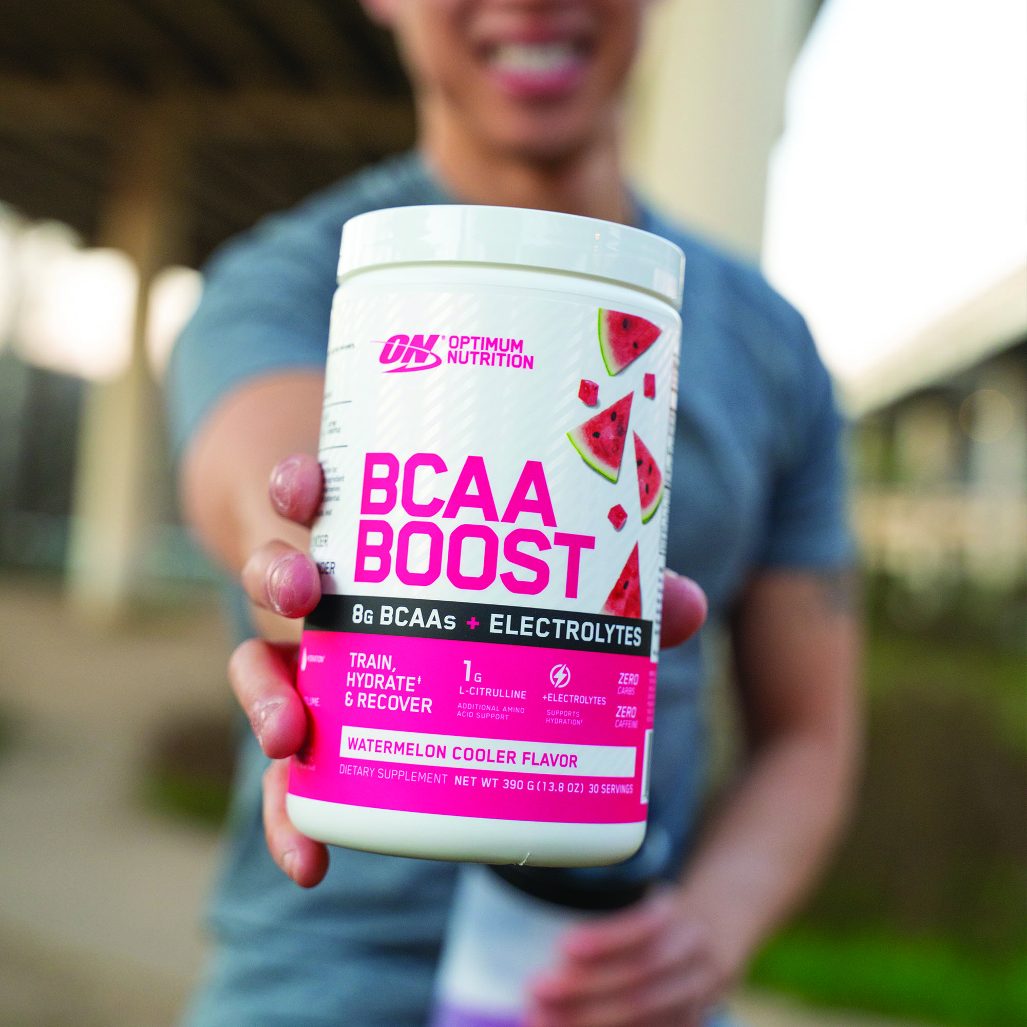 man holding tub of optimum nutrition boost BCAAS