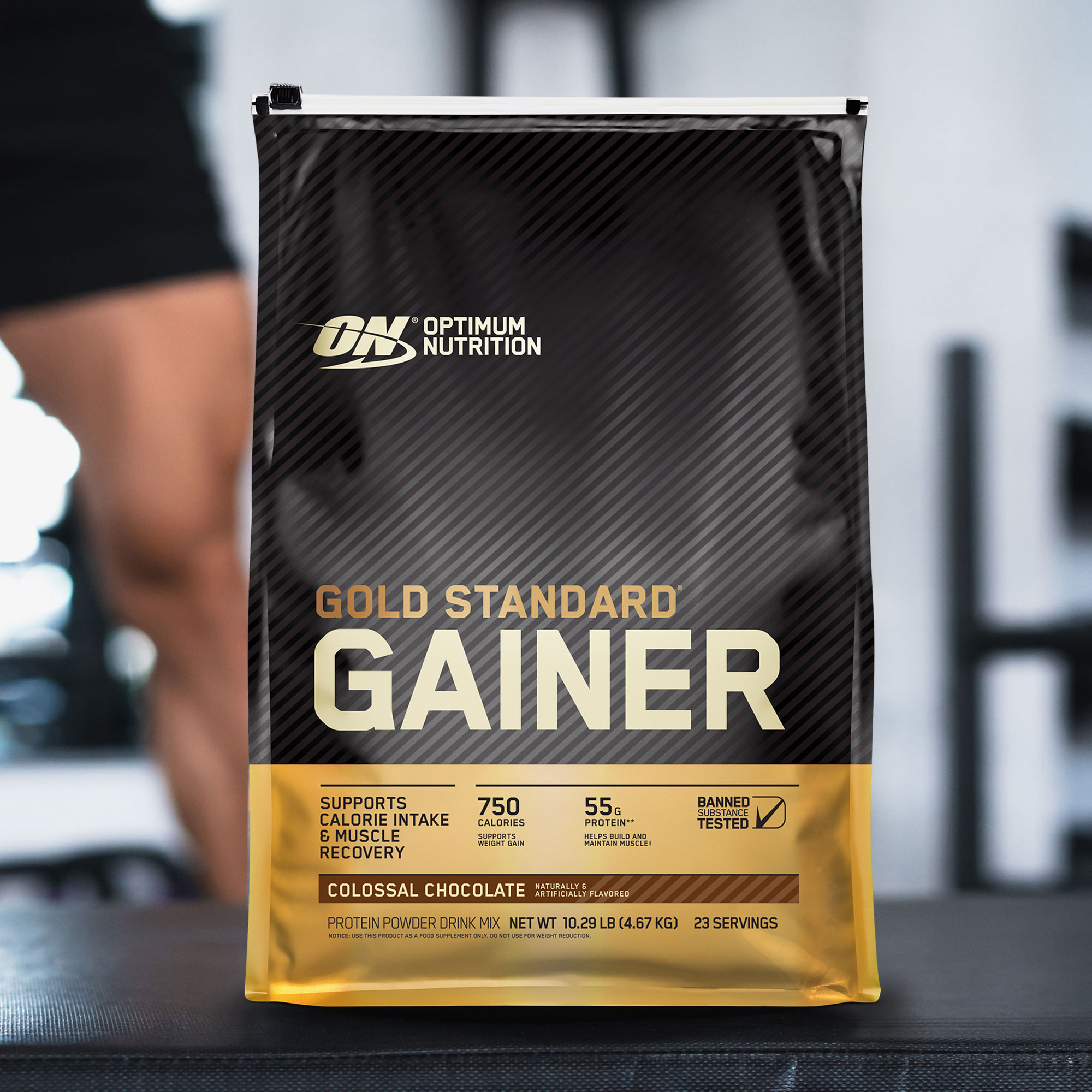 a pouch of optimum nutrition gold standard gainer with mans leg in background