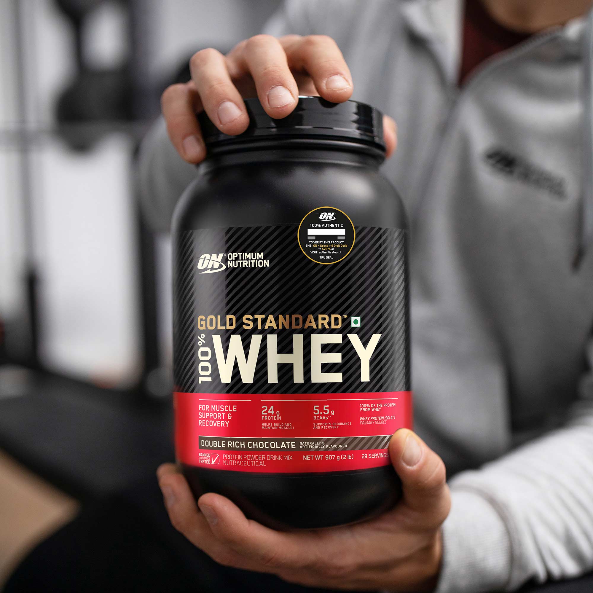 man holding tub of optimum nutrition gold standard 100% whey