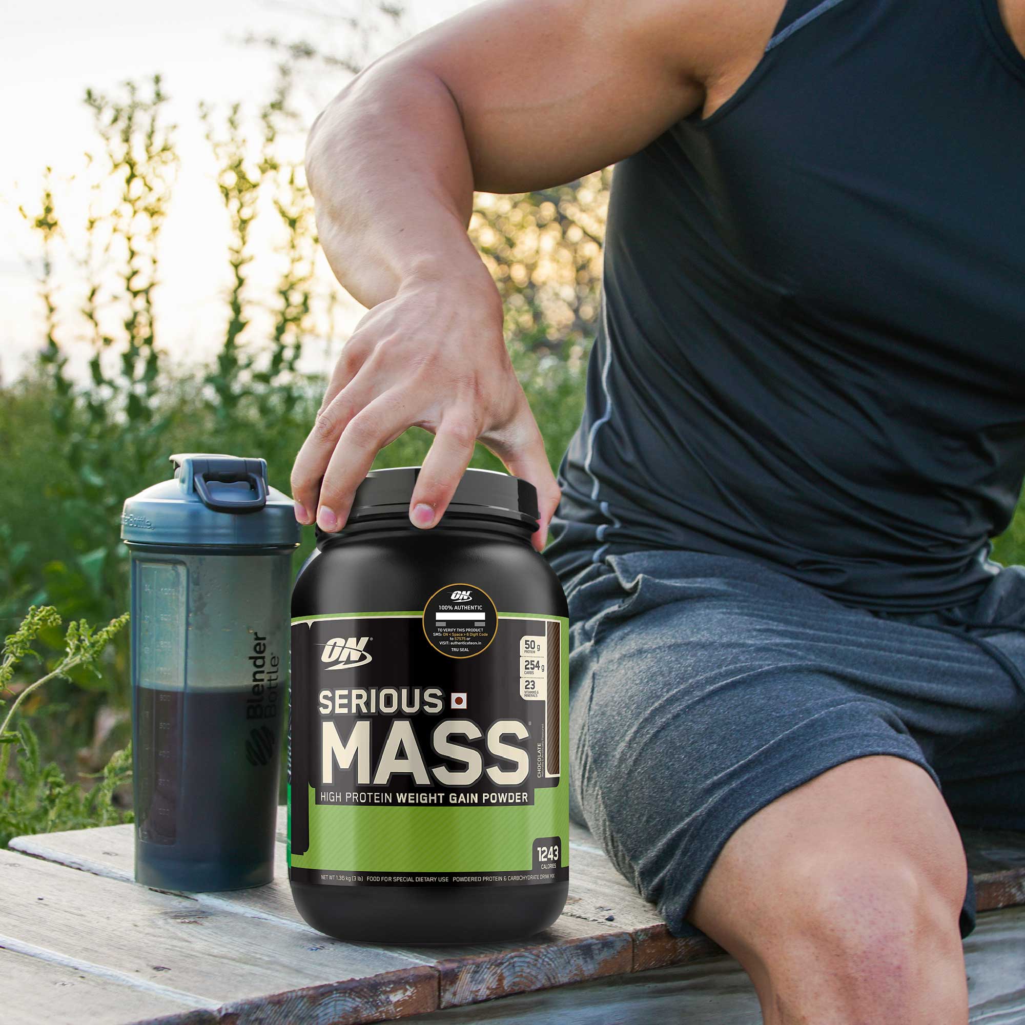 a man in gym gear placing his hand on a tub of serious mass powder